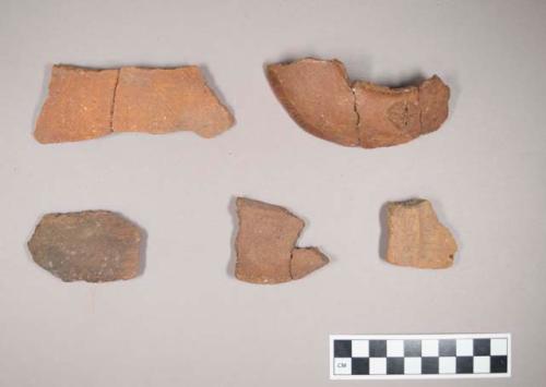 Restored rim section of pottery vessel and 3 potsherds