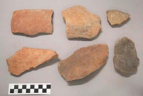 Earthenware vessel rim and body sherds, most with red paint decoration. Some Charred.