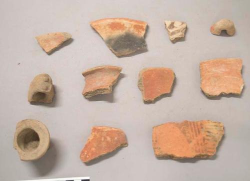 Earthenware vessel rim, body, handle, and base sherds. Some with red paint decoration, some with polychrome, some with red on buff decoration. One with molded and incised decoration.  One pedestal base, some foot ring bases, and several loop handles, one with molded design.