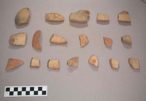 Earthenware vessel rim and body sherds, most with red paint decoration. Some with red on white decoration.