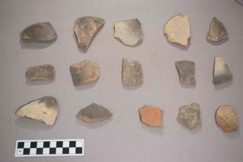 Earthenware vessel body sherds. Most with red paint decoration. Some white. Many with charring.