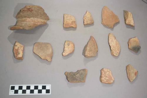 Earthenware vessel rim and body sherds. Most red on white paint decoration. Some rims are flared. Some body sherds with incised decoration.