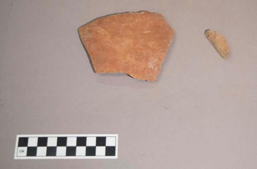 Earthenware vessel body and base sherds with red paint exterior decoration