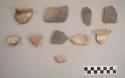 Earthenware vessel rim and body sherds. Red painted exterior, undecorated interior.