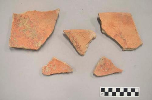 Earthenware vessel rim and body sherds with red paint decoration exterior and interior.