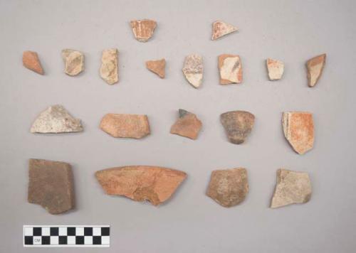 Earthenware vessel rim, body, and base sherds. Two large sherds, several small. Strap handles with modeled decoration and strap styled feet. Some charring.