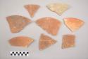 Earthenware plate-like vessel sherds. Vessel mended with stained plaster of paris and then subsequently broken again. Red painted interior and exterior (except plaster sherds).