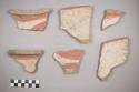 Earthenware vessel body sherds. Most decorated with red on white paint. Some with black paint on white painted exterior. Some highly burnished.