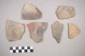 Earthenware vessel body sherds. Red on white painted exterior and interior. Charred.