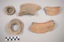 Earthenware vessel rim, body, and base sherds and a loop handle. Some red painted exterior. Some red on white paint decoration. Some with un-painted interior and exterior. Several sherds have incised lines on interior. Base sherd is the bottom of a cylindrical vessel leg.