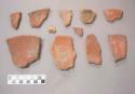 Earthenware vessel rim, body and ring foot base sherds. Red paint decorated interior and exterior. One sherd has polychrome decoration interior and red paint exterior.