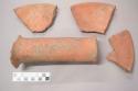 Earthenware vessel sherds with red painted interior and exterior. One large earthenware bar fragment.