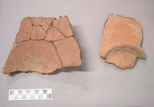 Earthenware vessel rim, body, and base sherds. Red paint interior and exterior. Foot ring base. Object was a plate shaped vessel. Object was reassembled and glued; since that point some of the glued fragements have become unglued. Some fragments have different object numbers.