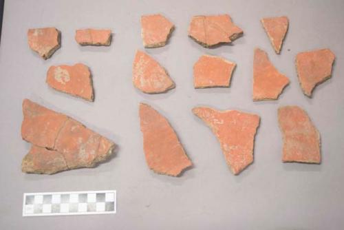 Earthenware vessel rim, body, and foot ring base sherds. Moswt with red painted exterior and interior. Some with unpainted exterior.