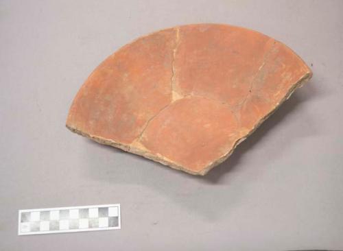 Earthenware vessel sherd. Sherd shows rim, body, and base portions. Red paint interior and exterior.