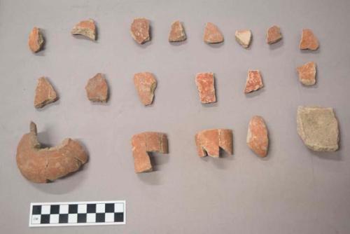 Earthenware vessel rim, body, and foot ring base sherds. Red painted exterior. Undecorated interior.