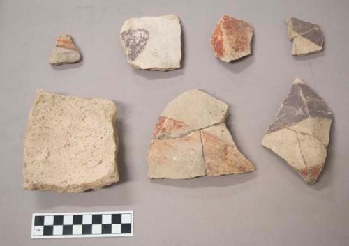 Earthenware vessel rim, body, and foot ring base sherds. Most have polychrome painted exterior and undecorated interior. Base sherd painted white with charring.