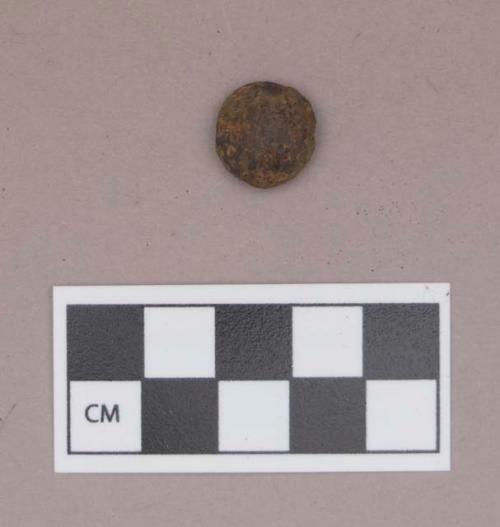 Metal, iron bead, round, domed, possible iron sheeting over another substance