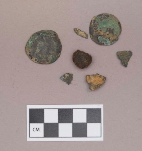 Metal, copper alloy domed disks and fragments, one with two perforations; iron domed disk fragment