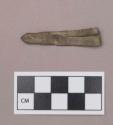 Metal, copper alloy folded sheet object, pointed at one end, notched and serrated on sides