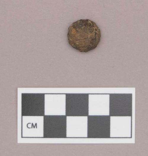 Domed clay ornament, covered with iron sheet, with partial perforation on flat surface, possible bead or button