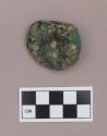 Metal, copper alloy ear spool fragment, with charcoal fragments adhered to it