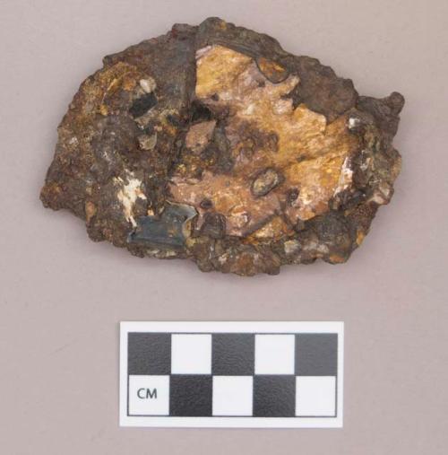 Metal, iron fragment, possibly worked, with mica fragments, calcined bone fragment, and pearl adhered to its surface