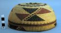 Klamath twined basketry cap. Yellow background w/ black and red geometric design.