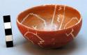 Circular red slipped bowl, with white lattice type pattern. 4" w., 2" h.