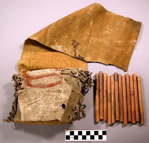 Northwest coast gambling kit. Leather bag containing carved wood sticks.