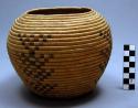 Coiled basket, natural color with four geometric designs.