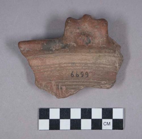 Earthenware rim sherd with modeled handle and incised designs on rim and body