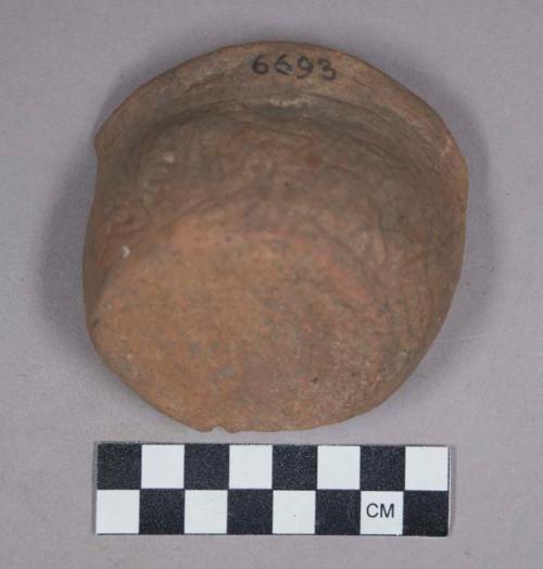 Earthenware bowl with incised designs, broken in half