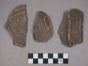 Earthenware rim and body and base sherds with carved designs