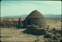 Daughter in front of shepherdess' house, in the field where she watches over the sheep