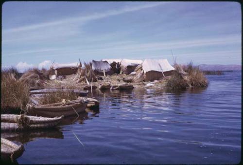 Harbor on floating island (Uros islands), with reed canoes and huts