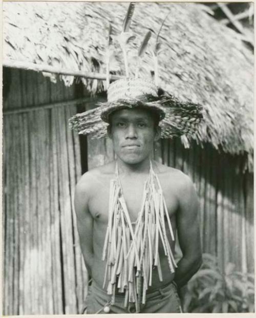 Kantule (ceremonial chanter) wearing feather hat and pelican bone flutes for chicha fiesta