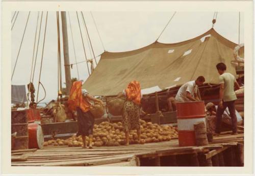 Women selling coconuts to a Columbian boat