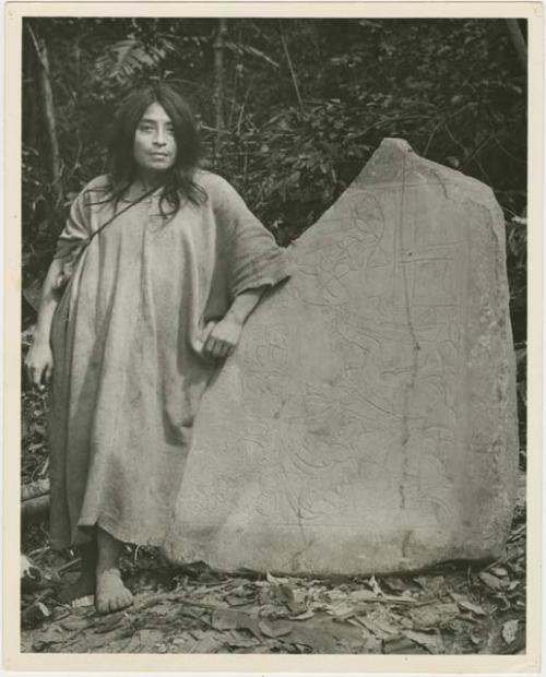 Man stands beside segment of altar stone