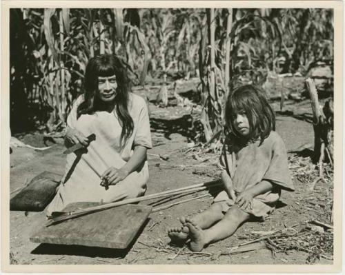 Father instructs his son in making arrows