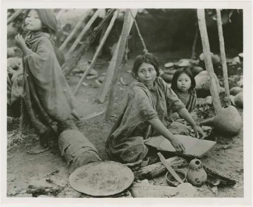 Women grind corn and make tortillas