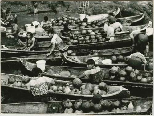 Women and girls at the river filling water gourds and washing clothes