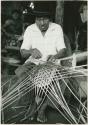 Man in hat basket weaving