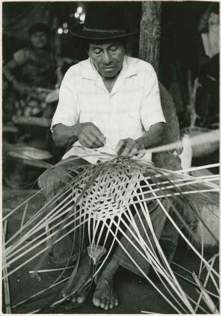 Man in hat basket weaving