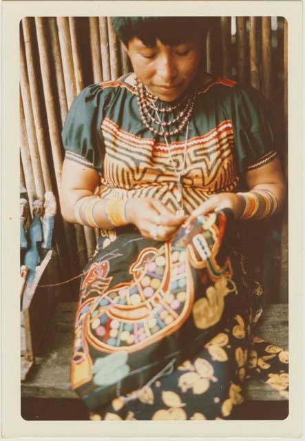 Woman sewing mola blouse