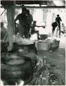 Preparations for the chicha fiesta, men boiling sugar cane juice inside chicha house