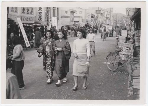 Women in traditional and modern dress, walking down street