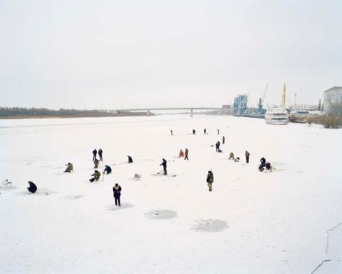 "Fisherman cut holes in the frozen river on the outskirts of the city.  Astrakhan, Russia, 2012"