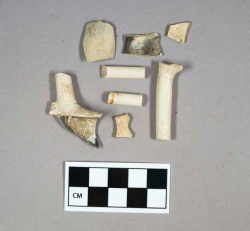 Kaolin, pipe bowl, fragments (4); pipe stems, 4/64" bore (2), 5/64" bore (1), 5/64" bore (1, with partial bowl attached, showing makers mark "L").