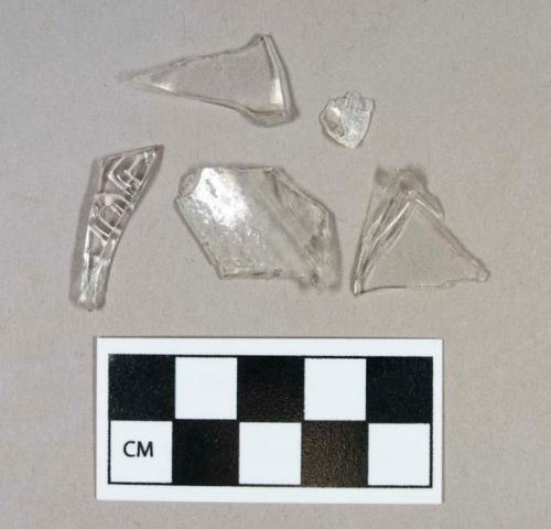 Glass, curved, clear, fragments - one with lettering, "D-E"